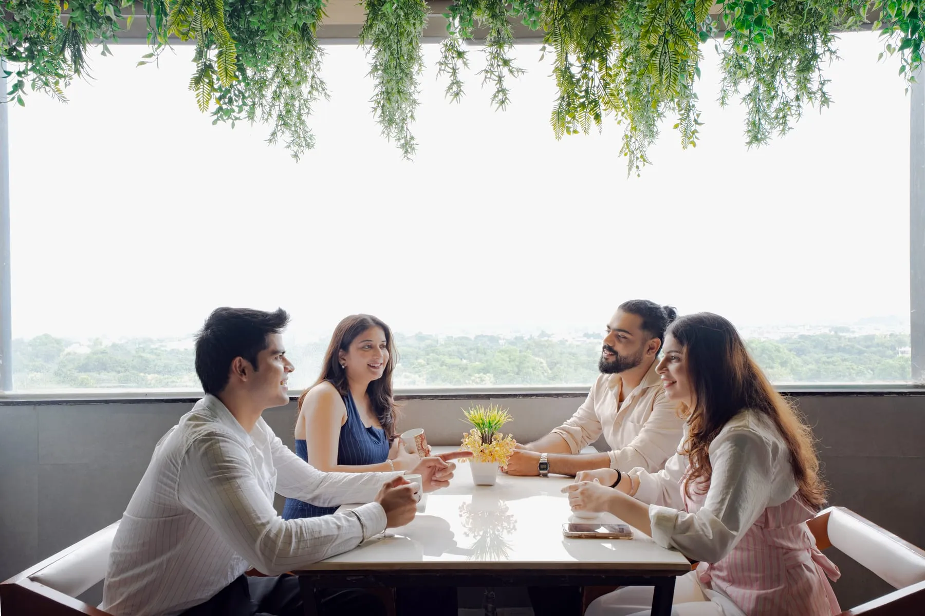 Four people at a café window table