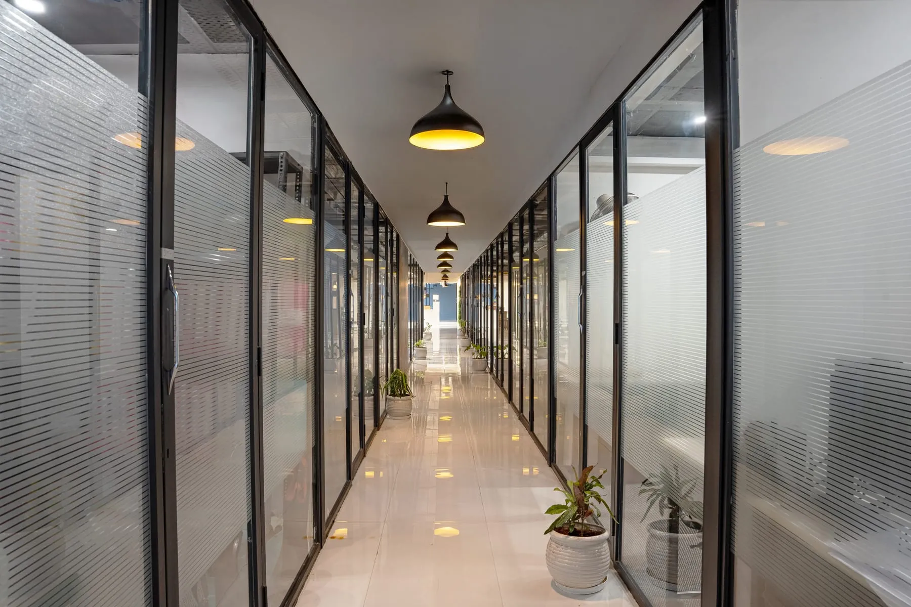 Glass cabin fronts and planters along the corridor