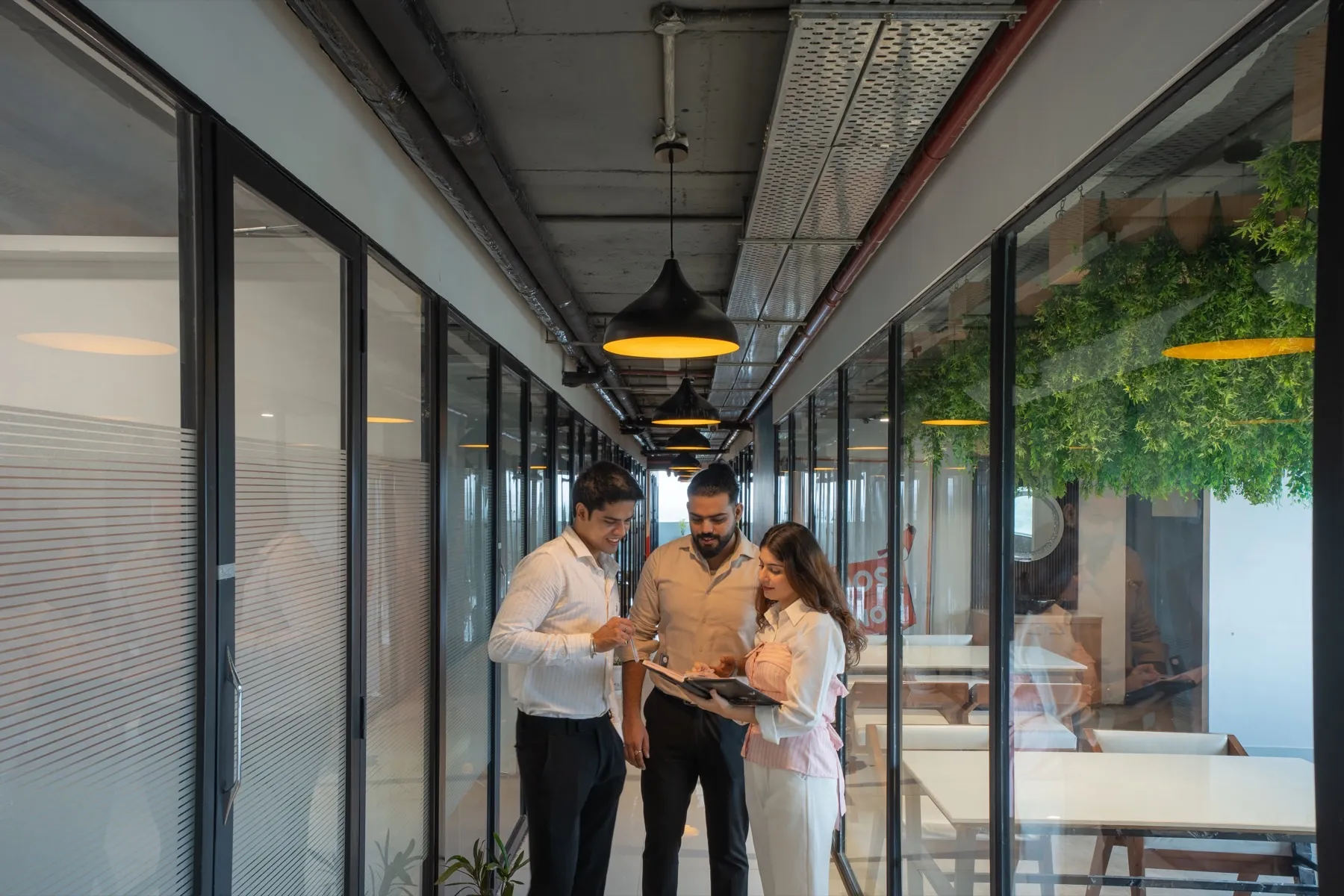 Three people with a tablet in the corridor