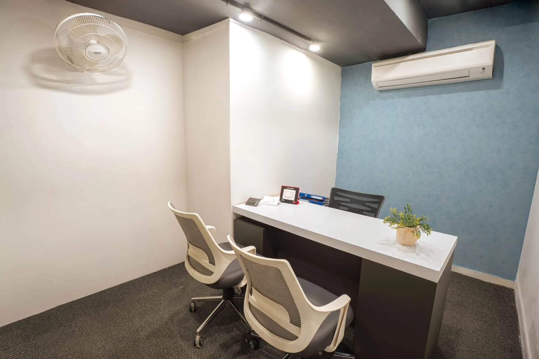 Director cabin with blue wall and visitor chairs